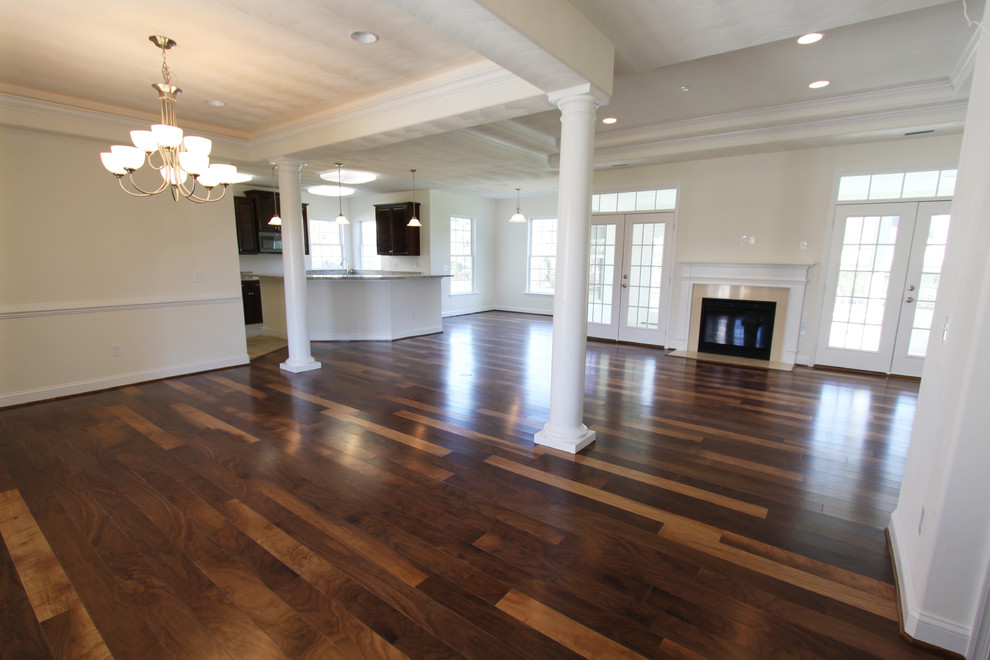Elegant dark wood floor great room photo in Other with beige walls, a standard fireplace and a stone fireplace
