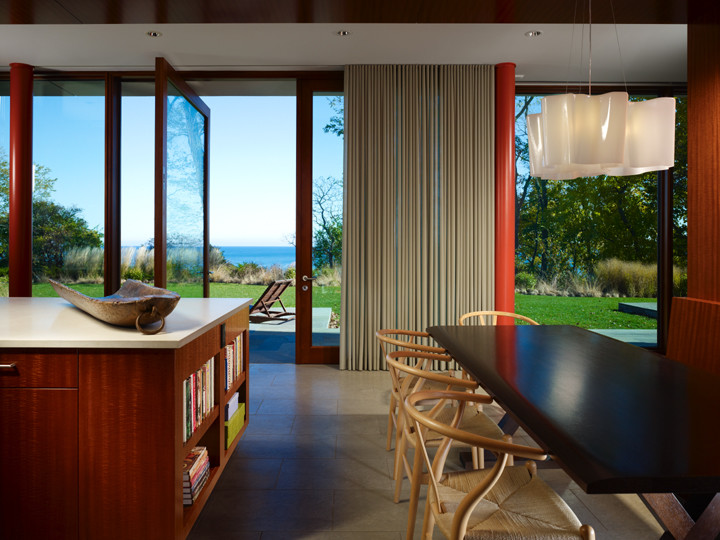 Foto di una piccola sala da pranzo aperta verso la cucina minimalista con pareti marroni e pavimento con piastrelle in ceramica