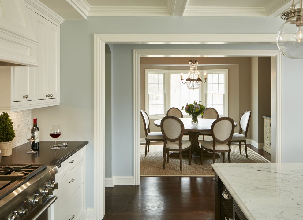 Immagine di una sala da pranzo aperta verso il soggiorno classica di medie dimensioni con pareti beige e parquet scuro