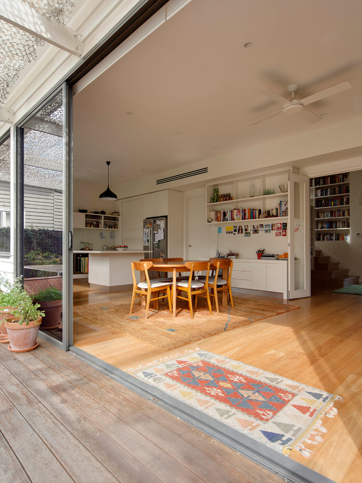 Mittelgroße Moderne Wohnküche mit weißer Wandfarbe, hellem Holzboden, Kamin und Kaminumrandung aus Metall in Melbourne
