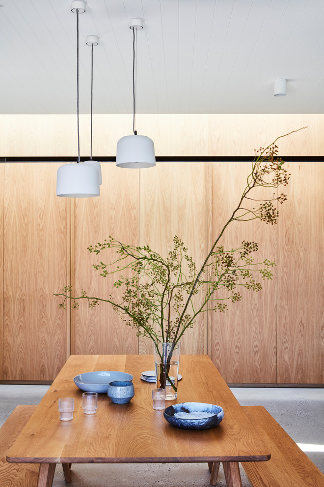 Réalisation d'une salle à manger ouverte sur le salon design avec sol en béton ciré et un sol gris.