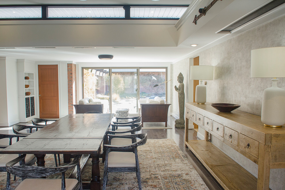 Foto di una grande sala da pranzo aperta verso il soggiorno moderna con pareti beige, parquet scuro, camino classico e pavimento marrone