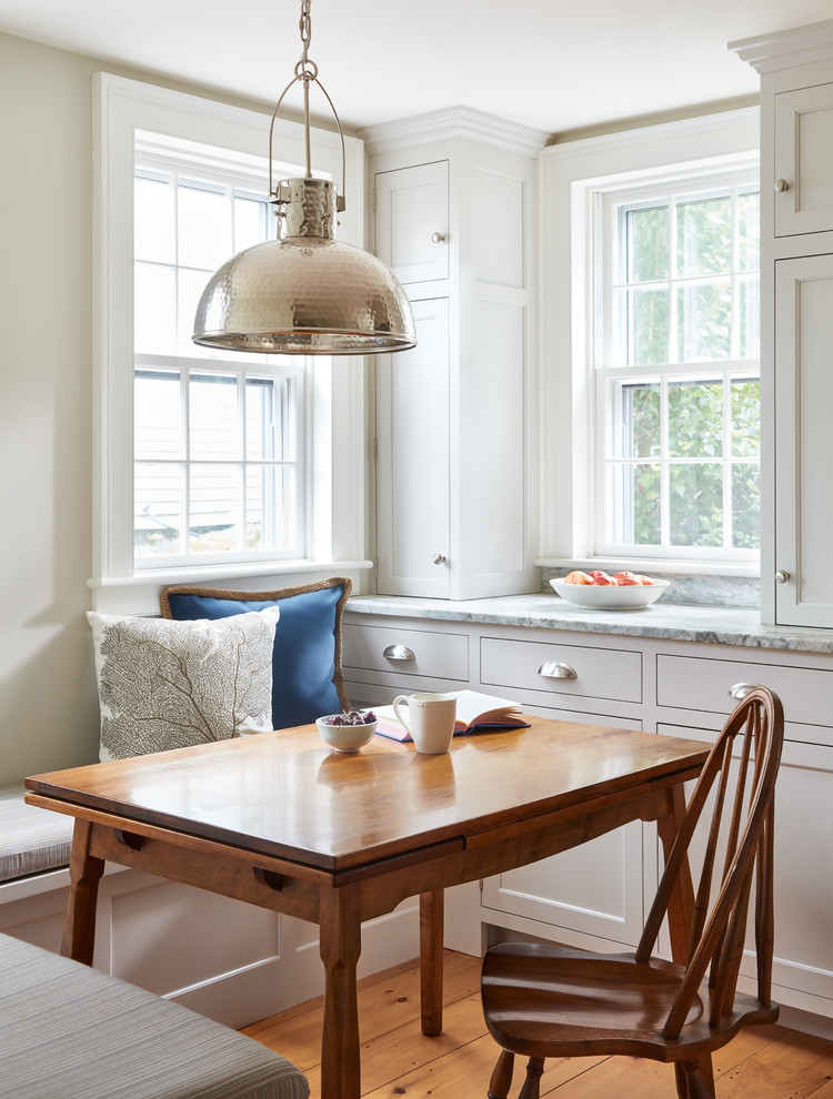 This is an example of a traditional kitchen/dining room in Boston with grey walls, medium hardwood flooring and brown floors.