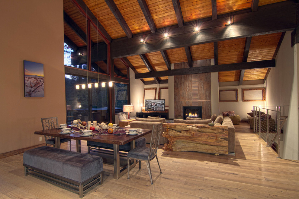 Idée de décoration pour une salle à manger ouverte sur le salon chalet avec un mur beige et un sol en bois brun.