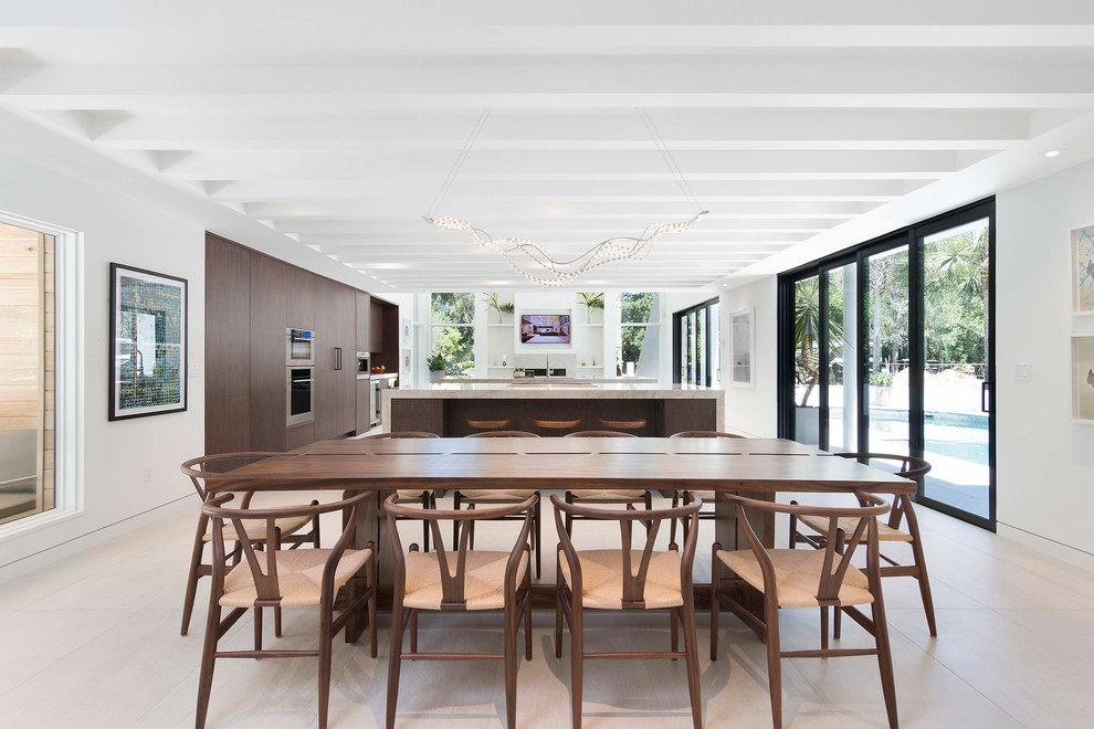 Inspiration pour une salle à manger ouverte sur le salon design avec un mur blanc et un sol beige.