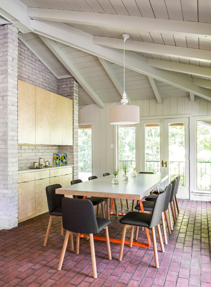 Design ideas for a contemporary enclosed dining room in Little Rock with white walls and brick flooring.