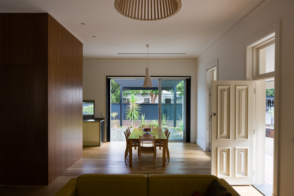 Ispirazione per una sala da pranzo aperta verso il soggiorno contemporanea di medie dimensioni con pareti bianche e pavimento in legno massello medio