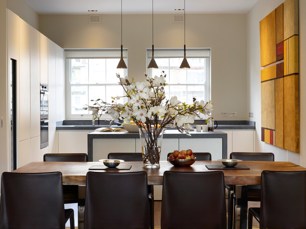 Idee per una piccola sala da pranzo aperta verso il soggiorno minimal con parquet scuro, pavimento marrone e pareti beige