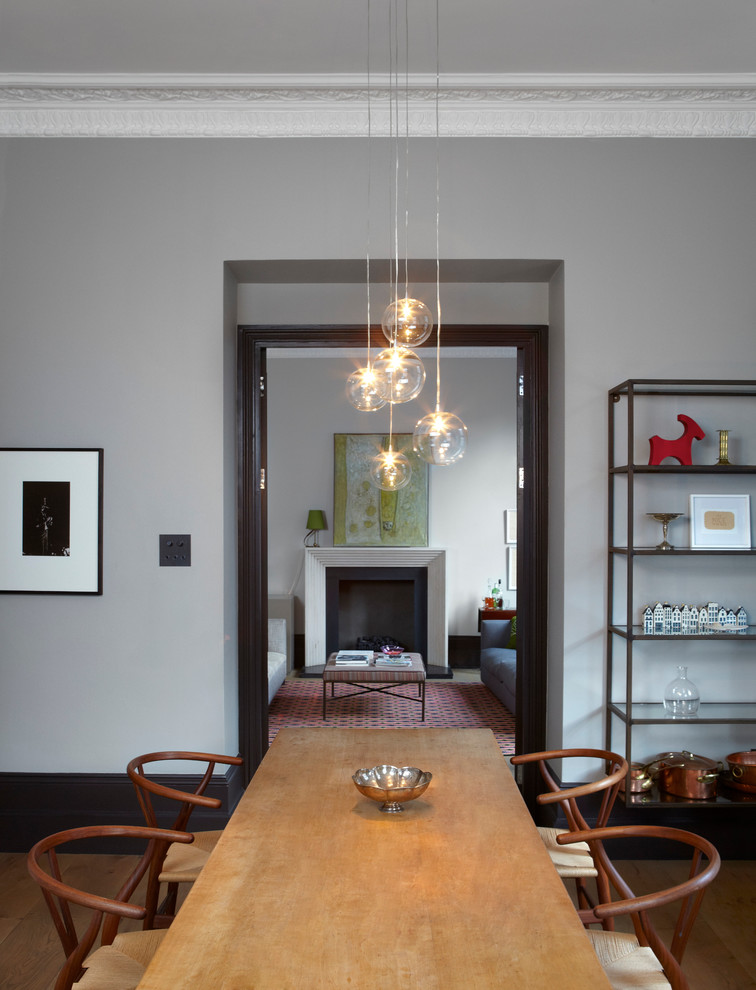 This is an example of a modern dining room in London with grey walls.