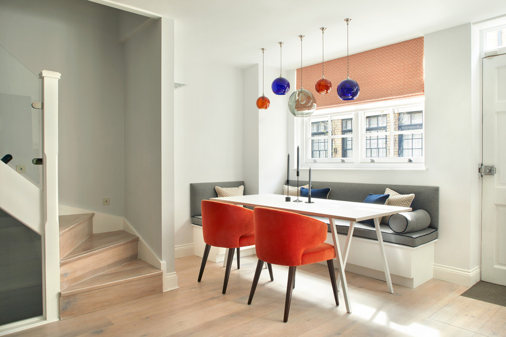 Ispirazione per una piccola sala da pranzo aperta verso la cucina minimalista con pareti grigie, parquet chiaro e pavimento beige
