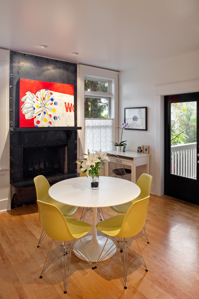Eclectic medium tone wood floor dining room photo in Portland with white walls and a standard fireplace