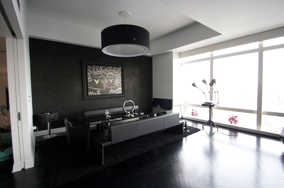 Стильный дизайн: большая гостиная-столовая в стиле модернизм с черными стенами, темным паркетным полом и черным полом без камина - последний тренд