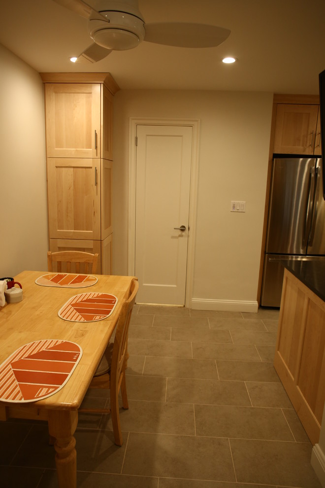 Cette image montre une petite salle à manger ouverte sur la cuisine design avec un mur beige, un sol en ardoise et aucune cheminée.