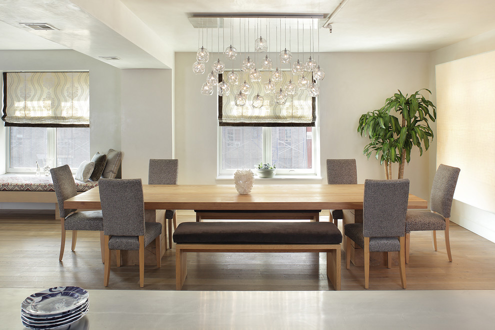 Immagine di una sala da pranzo aperta verso il soggiorno bohémian con pareti beige e pavimento in legno massello medio