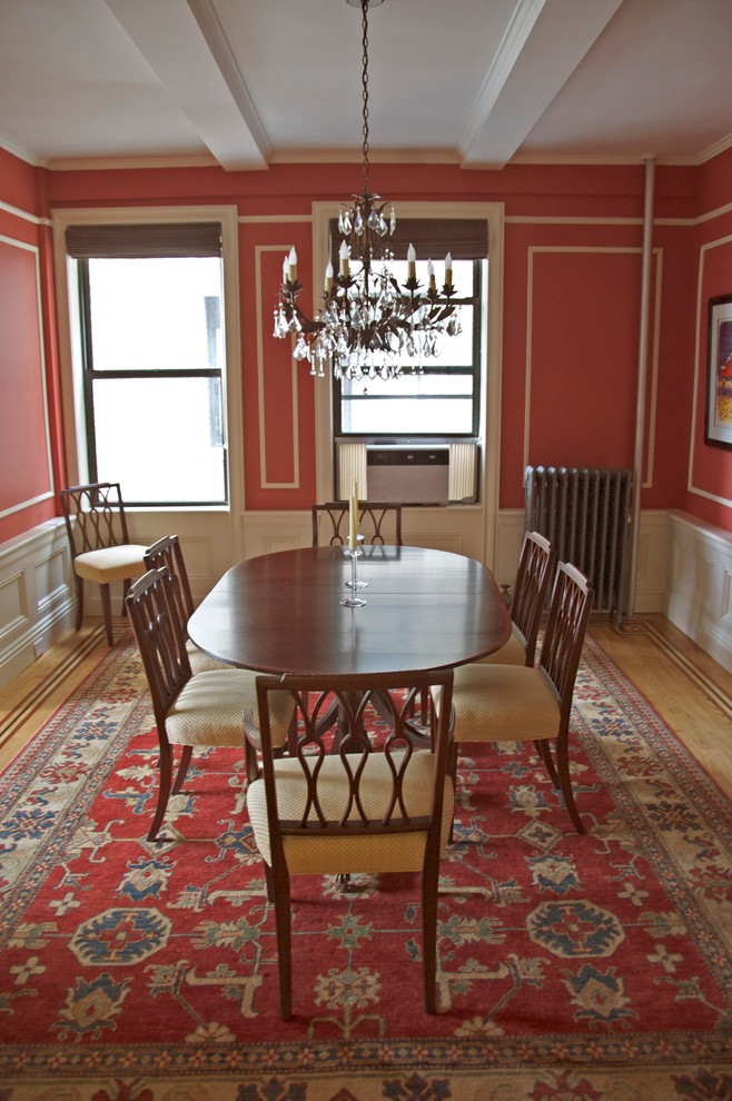 Inspiration pour une salle à manger traditionnelle fermée et de taille moyenne avec un mur rouge, parquet clair, aucune cheminée et un sol beige.