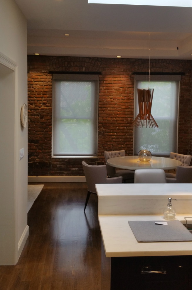 Ispirazione per una sala da pranzo aperta verso il soggiorno industriale con pareti bianche e pavimento in legno massello medio