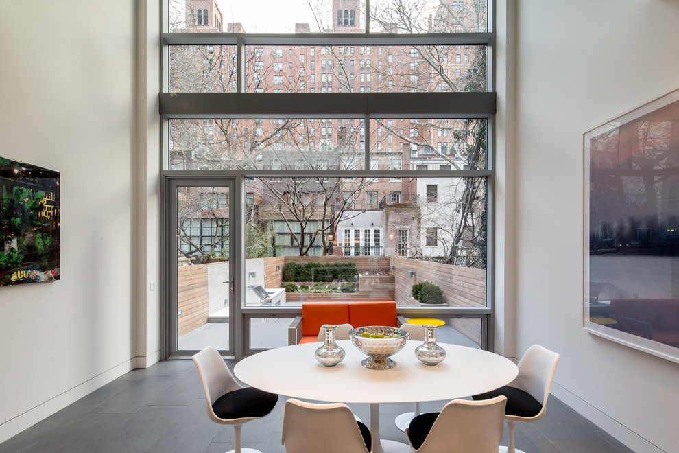 Esempio di una sala da pranzo aperta verso il soggiorno contemporanea con pavimento grigio