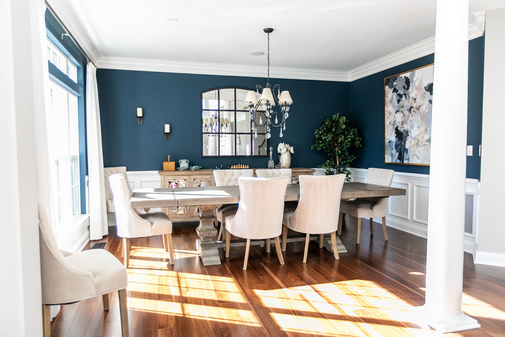Modelo de comedor clásico renovado grande con paredes azules, suelo de madera en tonos medios y suelo marrón