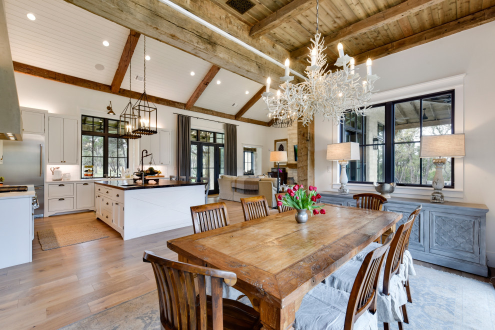 Große Landhaus Wohnküche mit weißer Wandfarbe, hellem Holzboden und beigem Boden in Austin