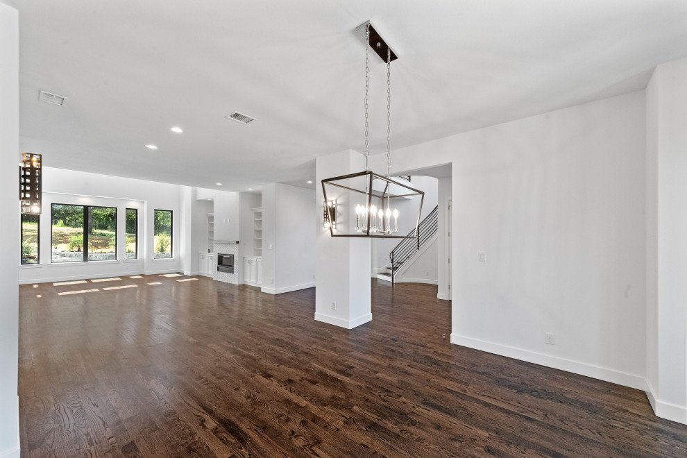 Idée de décoration pour une salle à manger ouverte sur le salon design de taille moyenne avec un mur blanc, un sol en bois brun et un sol marron.
