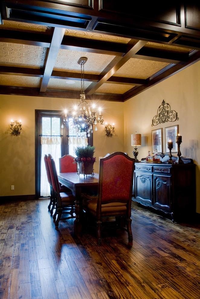 Immagine di una grande sala da pranzo classica chiusa con pareti gialle, parquet scuro, nessun camino e pavimento beige