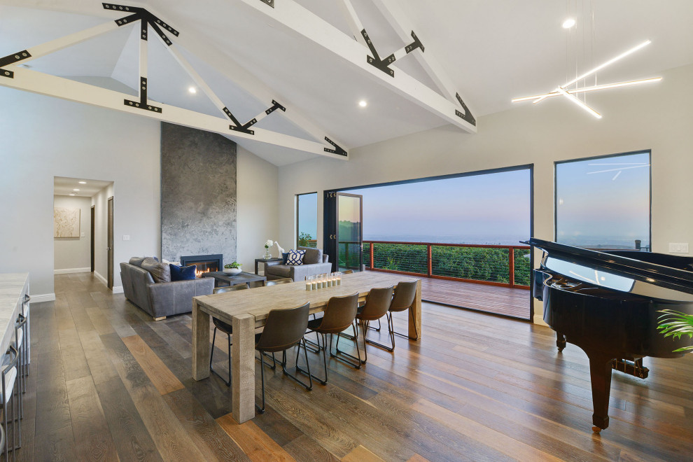 Идея дизайна: большая гостиная-столовая в стиле модернизм с серыми стенами, темным паркетным полом, коричневым полом и балками на потолке