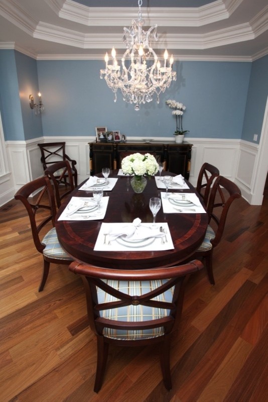 Foto di una sala da pranzo classica chiusa e di medie dimensioni con pareti blu, pavimento in legno massello medio e nessun camino