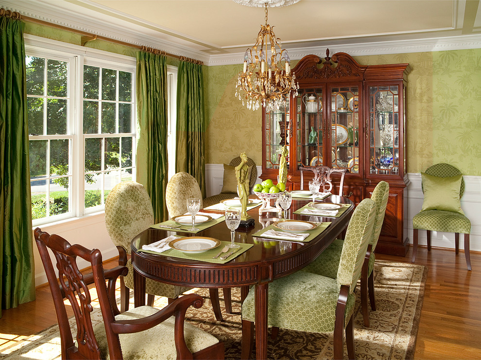 Modelo de comedor clásico con paredes verdes y suelo de madera en tonos medios