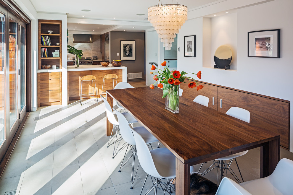 Immagine di una sala da pranzo aperta verso la cucina contemporanea con pareti bianche