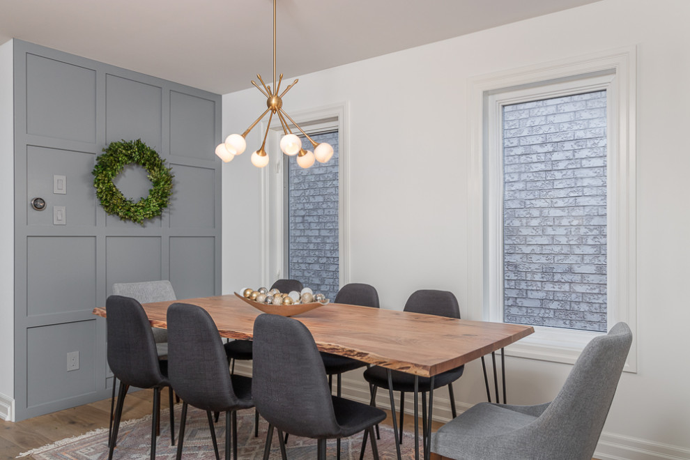 Ispirazione per una piccola sala da pranzo aperta verso il soggiorno chic con pareti grigie, parquet chiaro e pavimento marrone