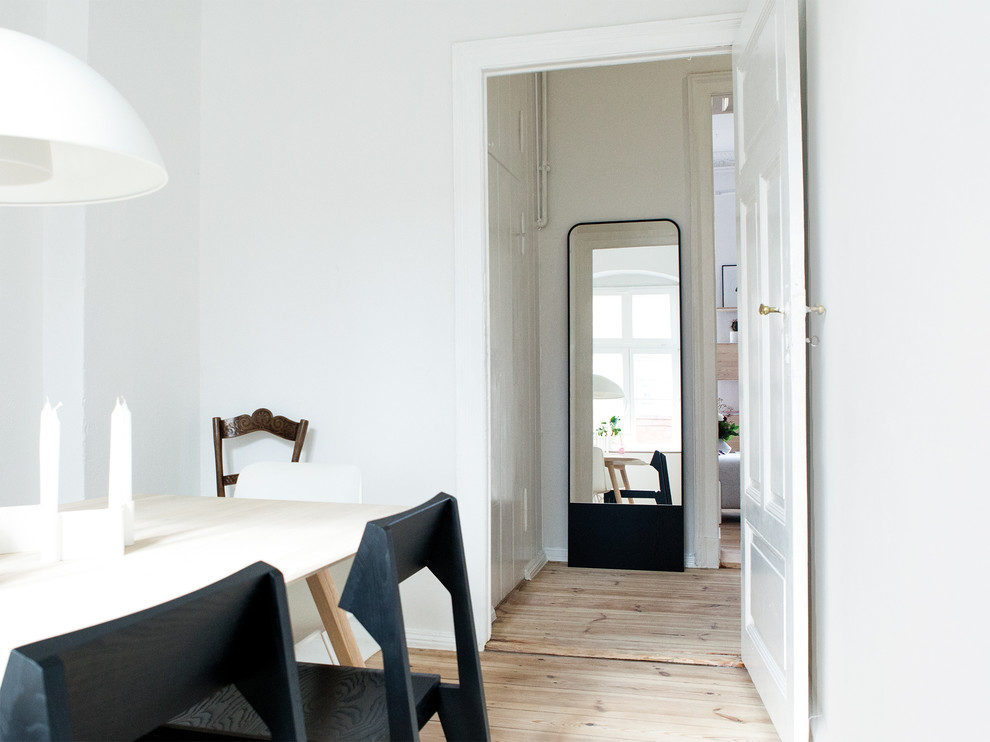 На фото: кухня-столовая в стиле модернизм с белыми стенами и светлым паркетным полом с