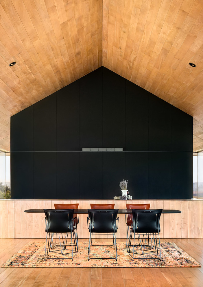 Idee per una sala da pranzo moderna con pareti nere e pavimento in legno massello medio