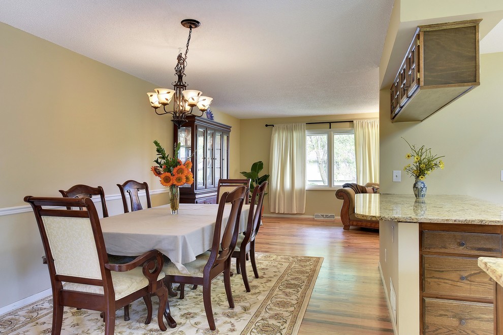 Foto di una sala da pranzo aperta verso la cucina chic di medie dimensioni con pareti beige, pavimento in legno massello medio e pavimento marrone