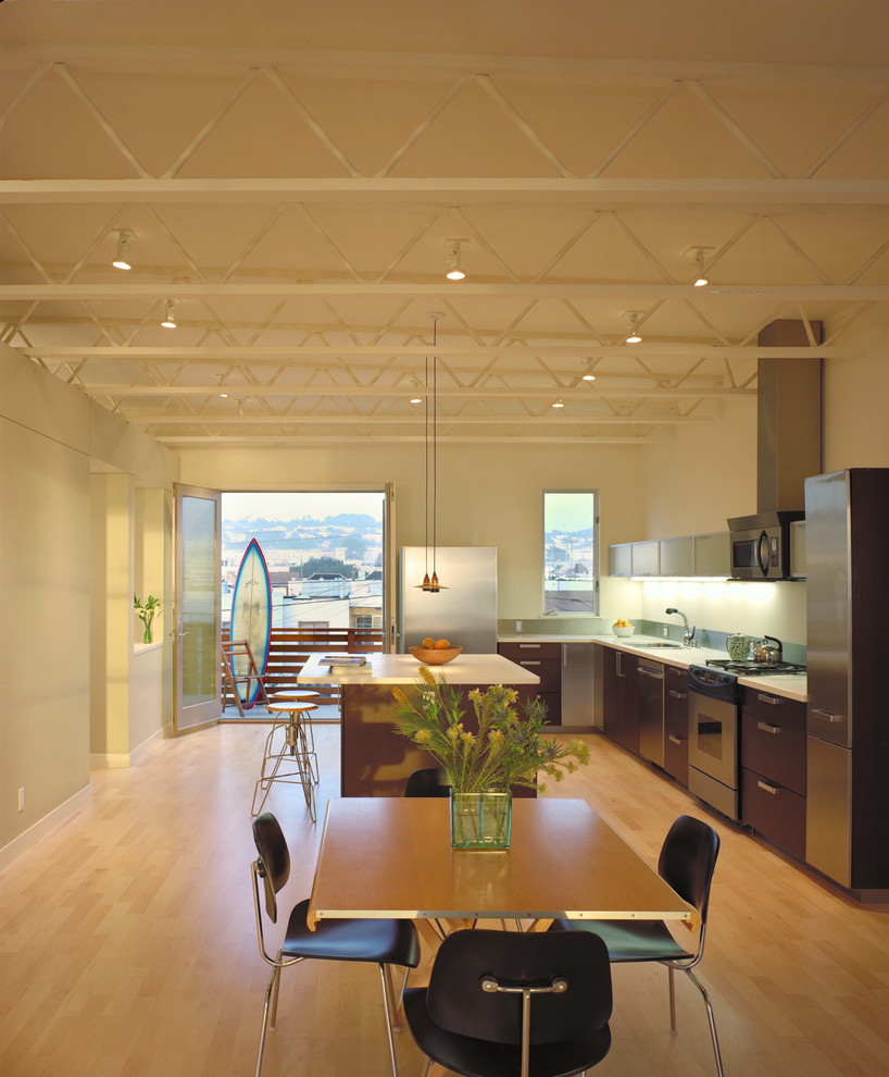 Inspiration pour une salle à manger ouverte sur la cuisine minimaliste avec un mur beige et un sol en bois brun.