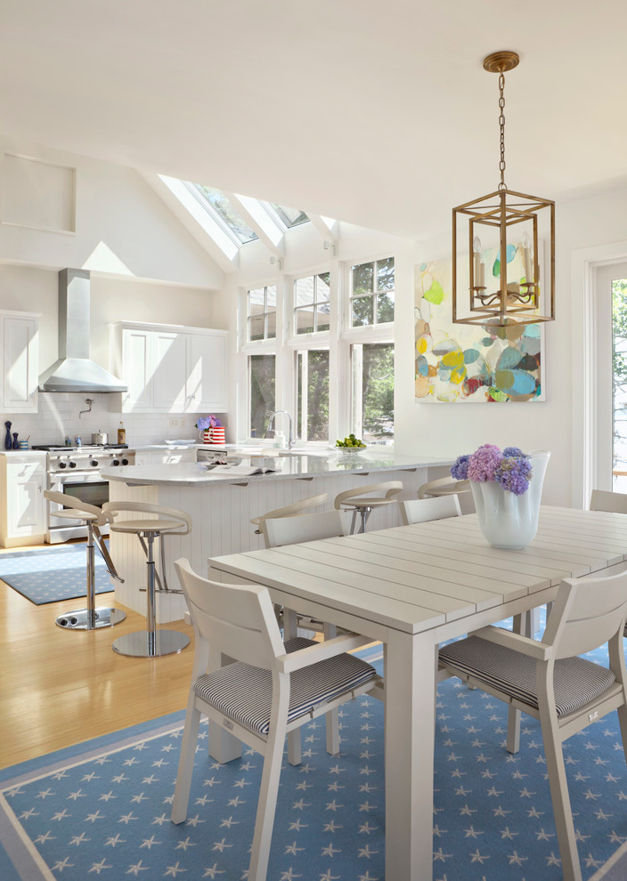 Esempio di una sala da pranzo aperta verso la cucina stile marinaro con pareti bianche e pavimento in legno massello medio