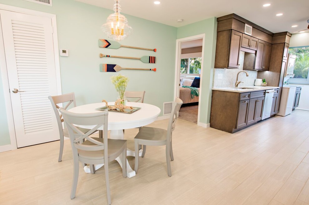 Esempio di una sala da pranzo aperta verso la cucina stile marino di medie dimensioni con pareti verdi, parquet chiaro e pavimento beige