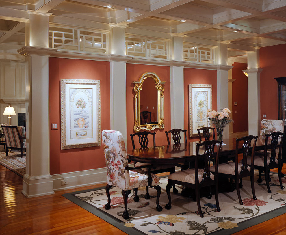 Esempio di un'ampia sala da pranzo aperta verso il soggiorno classica con pavimento in legno massello medio e pareti arancioni