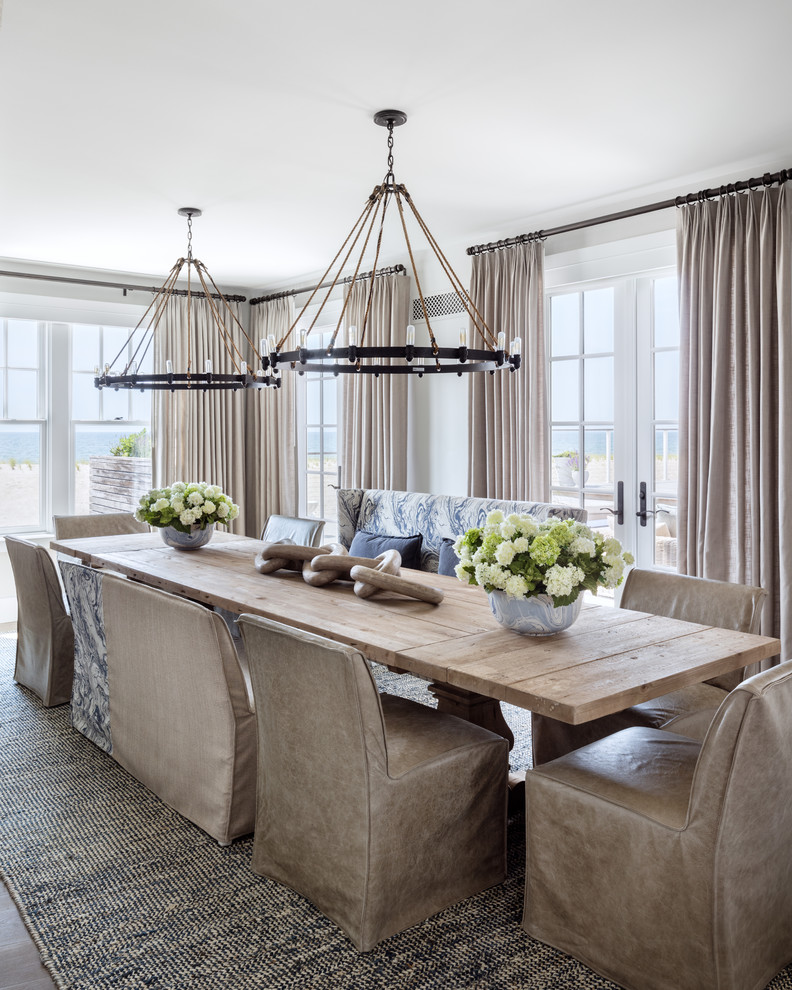 Immagine di una sala da pranzo aperta verso il soggiorno stile marino con pareti beige, parquet chiaro e pavimento beige