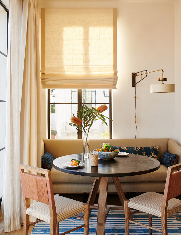 Idées déco pour une salle à manger méditerranéenne avec un mur blanc, un sol en bois brun et un sol marron.