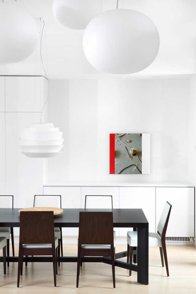 Foto de comedor minimalista con paredes blancas y suelo de madera clara