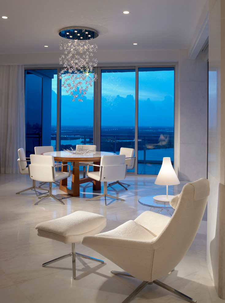 This is an example of a large contemporary open plan dining room in Miami with white walls, marble flooring, no fireplace, white floors and feature lighting.