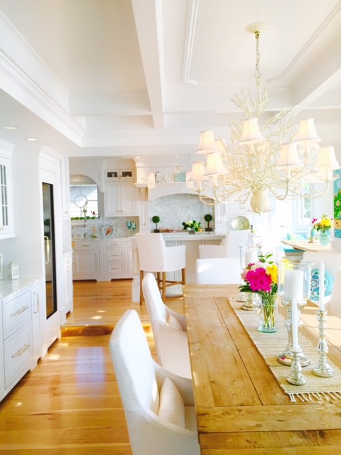 Cette photo montre une grande salle à manger ouverte sur la cuisine bord de mer avec un mur blanc et parquet en bambou.