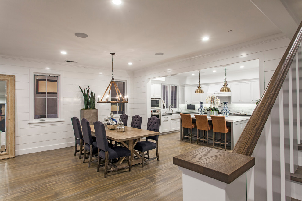 Design ideas for a large coastal kitchen/dining room in Orange County with white walls and dark hardwood flooring.