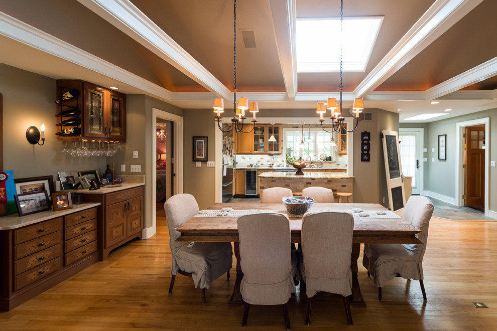 Cette image montre une salle à manger ouverte sur la cuisine traditionnelle de taille moyenne avec un mur beige, un sol en bois brun et aucune cheminée.