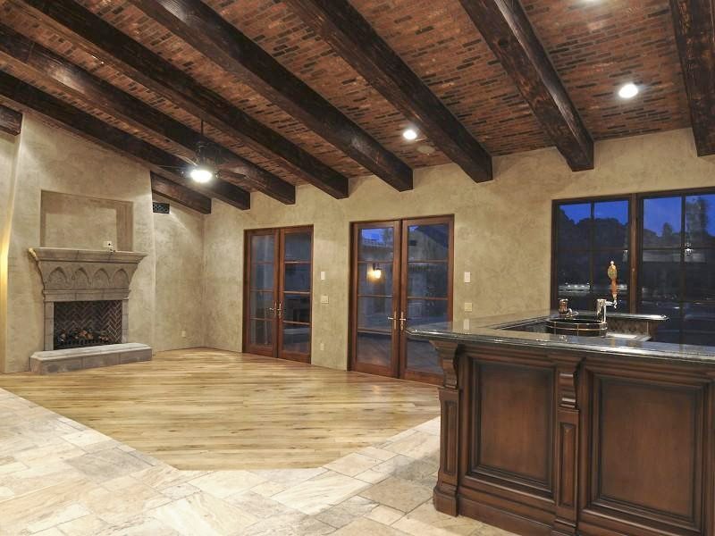 フェニックスにある高級な広いエクレクティックスタイルのおしゃれなダイニングキッチン (茶色い壁、淡色無垢フローリング、両方向型暖炉、石材の暖炉まわり) の写真