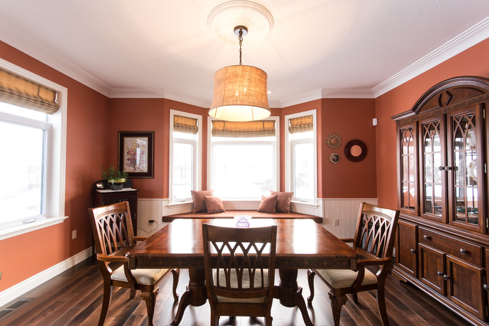 На фото: большая кухня-столовая в стиле кантри с оранжевыми стенами, паркетным полом среднего тона и коричневым полом без камина