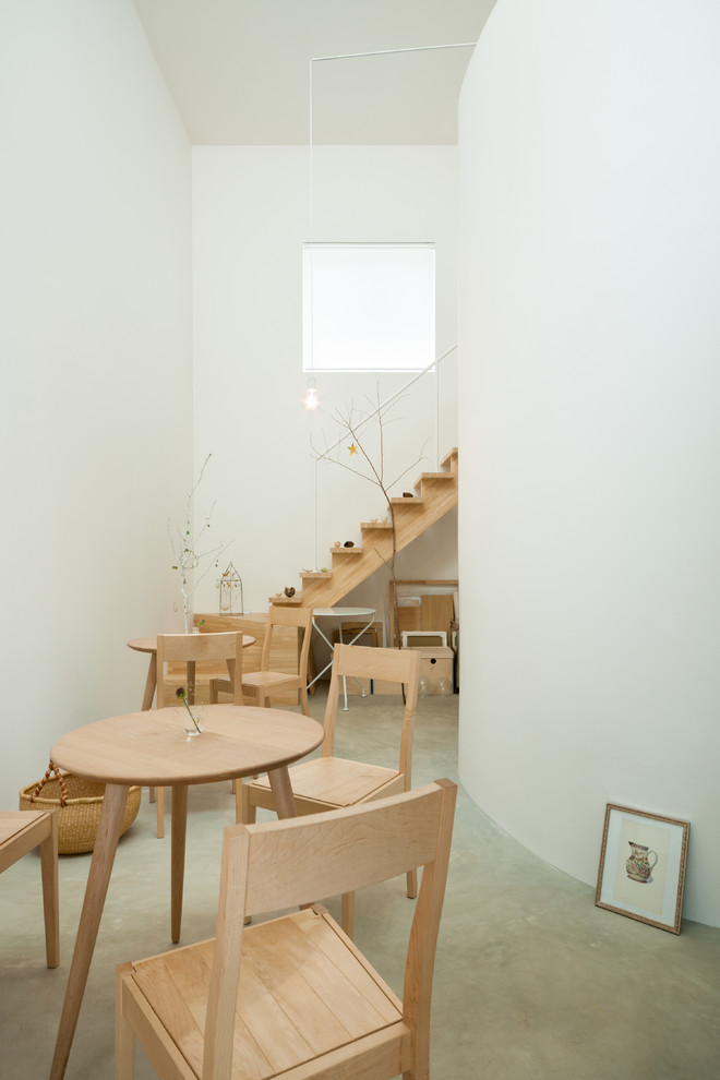 Kleines Modernes Esszimmer mit weißer Wandfarbe, Betonboden und grauem Boden