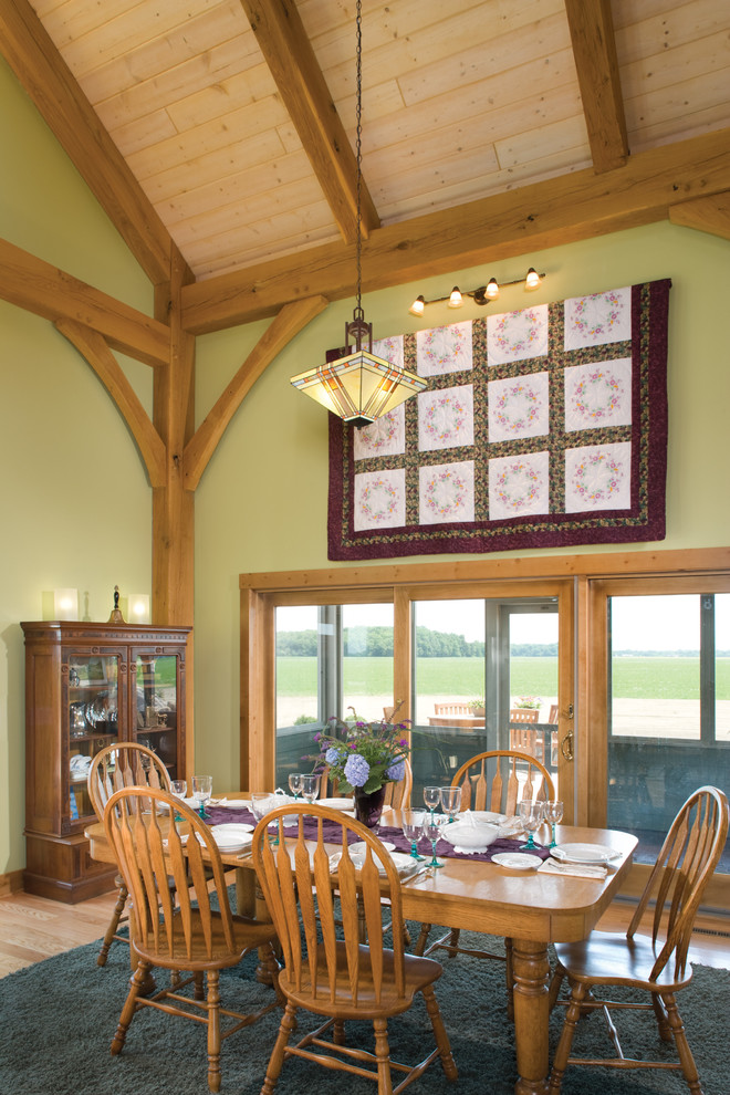 Imagen de comedor de estilo de casa de campo con paredes verdes y suelo de madera clara