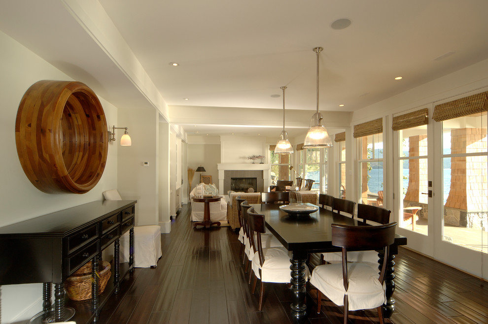 This is an example of a medium sized nautical open plan dining room in Vancouver with dark hardwood flooring, a standard fireplace, a tiled fireplace surround and white walls.