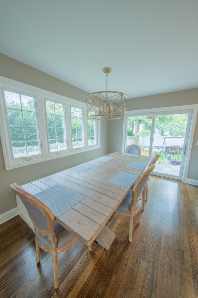 Immagine di una sala da pranzo aperta verso la cucina chic di medie dimensioni con pareti verdi, pavimento in legno massello medio e pavimento marrone